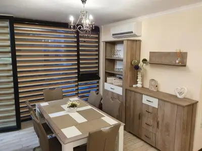a kitchen and dining room with a table and chairs at Апартамент За Гости ,,ХРИСТИНА