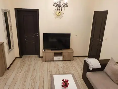 a living room with a television and a couch at Апартамент За Гости ,,ХРИСТИНА