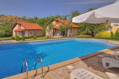 a swimming pool with chairs and a house at BulgariaVilla - Green Life Villas in Bryastovets