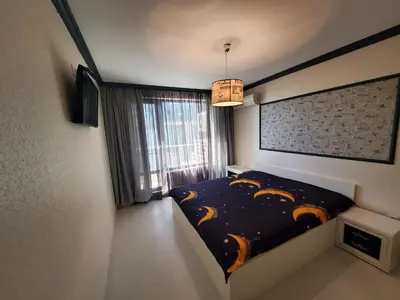 a bedroom with a bed and a large window at Апартамент Анели in Pomorie