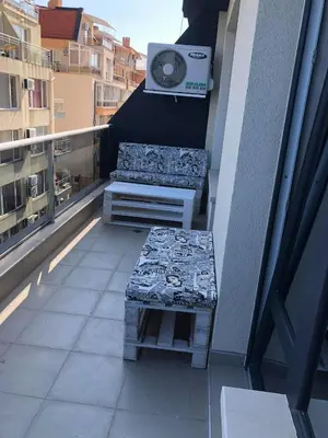 a balcony with two benches and a speaker on a building at Апартамент Анели in Pomorie