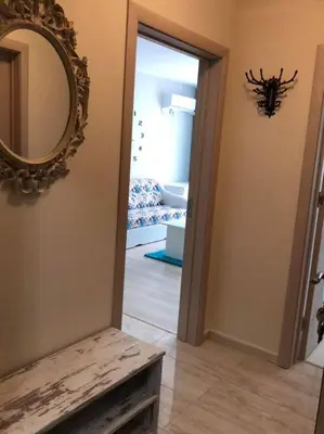 a hallway with a mirror and a room with a couch at Апартамент Анели in Pomorie