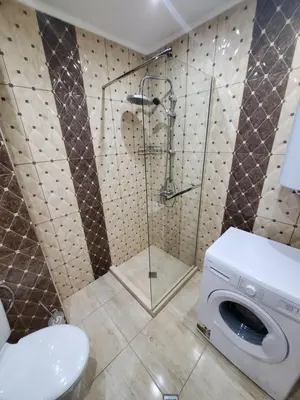 a bathroom with a shower and a washing machine at Апартамент Анели in Pomorie