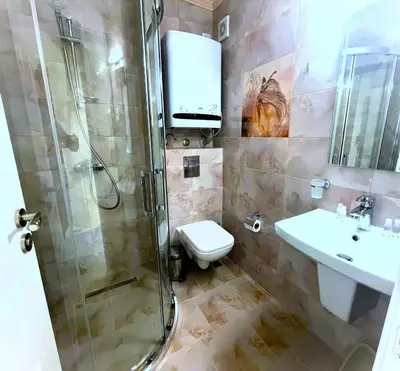 a bathroom with a shower and a toilet and a sink at Apartments Stamopolu Lux with pool view in Primorsko