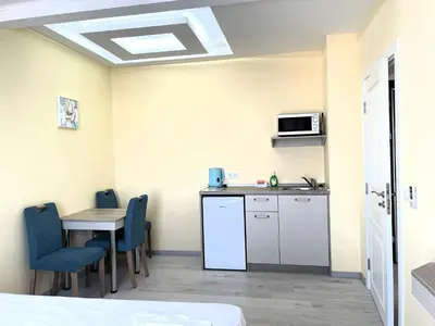 a room with a kitchen and a table with chairs at Sea View Apartment free parking in Primorsko