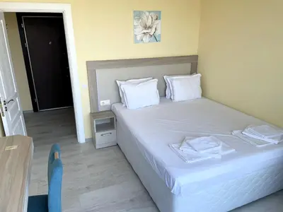 a bedroom with a bed with white sheets and white pillows at Sea View Apartment free parking in Primorsko