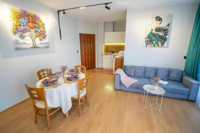 a living room with a blue couch and a table at Via Pontica 123 Guest Apartments in Sozopol
