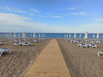 a row of chairs and umbrellas on a beach at Apartment Relax Lozenets in Lozenets
