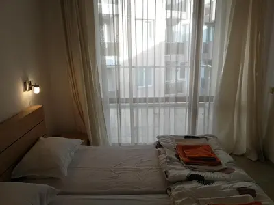 a bed in a room with a large window at Cozy family villa 500m. from the beach in Byala