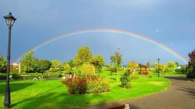 a rainbow over a park with a green lawn at Summer Apart Janet in Obzor