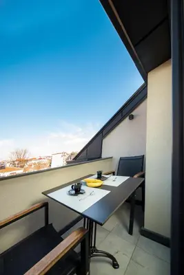 a balcony with a table and chairs and a window at Boutique Guest House