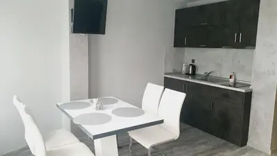 a kitchen with a table and white chairs and a sink at Boutique Guest House