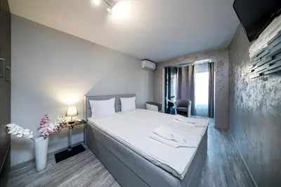 a bedroom with a white bed and a desk with a lamp at Boutique Guest House