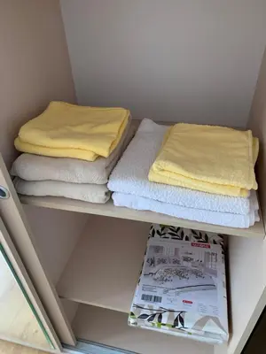 a shelf with folded towels and a magazine at Villa CALABRIA in Sveti Vlas