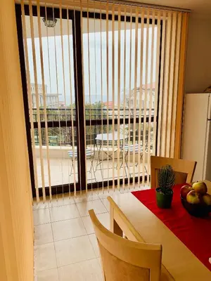 a dining room with a table and a view of a balcony at Villa CALABRIA in Sveti Vlas