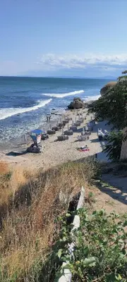 a beach with lounge chairs and the ocean at ЛЕСО-Зара студио in Ravda