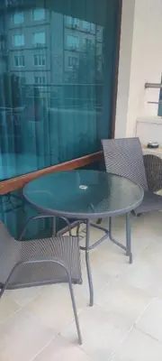 a glass table and chairs in a room with a window at ЛЕСО-Зара студио in Ravda