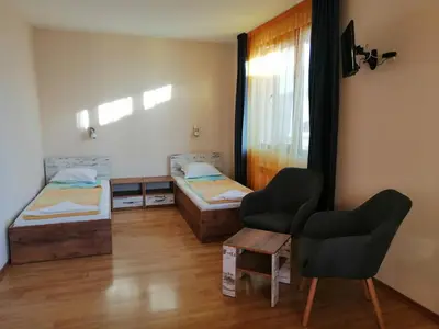 a room with two beds and a table and two chairs at Дом Апостолови in Sozopol