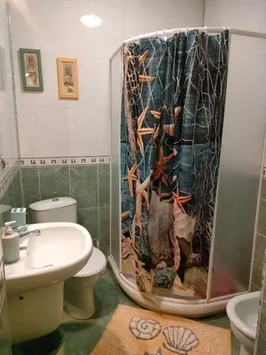 a shower curtain in a bathroom with a toilet and a sink at Самостоятелни стаи Виктория in Pomorie