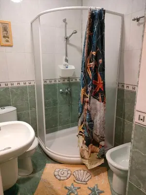 a bathroom with a shower with a toilet and a sink at Самостоятелни стаи Виктория in Pomorie
