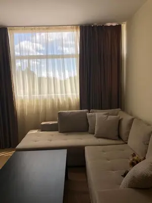 a living room with a couch and a large window at ELIT 2 APART HOTEL in Sunny Beach