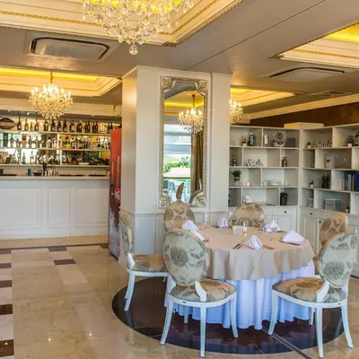 a dining room with a table and chairs and a kitchen at FLORENCE SUITES APART HOTEL in Sveti Vlas