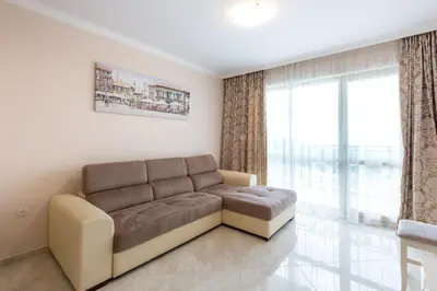 a living room with a couch and a large window at FLORENCE SUITES APART HOTEL in Sveti Vlas