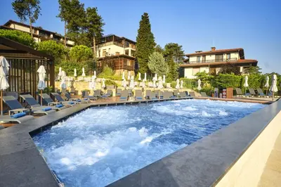 a swimming pool with chairs and umbrellas at Viva Mare Beach Hotel by Santa Marina in Sozopol