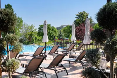 a row of chairs and umbrellas next to a pool at Viva Mare Beach Hotel by Santa Marina in Sozopol