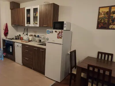 a kitchen with a refrigerator with a microwave on top of it at Byala COZY APARTMENT in Byala
