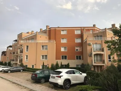 a large building with cars parked in front of it at Byala COZY APARTMENT in Byala