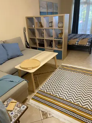 a living room with a couch and a table at Tiny Bijou Sea View studio - Santa Marina - Sozopol in Sozopol