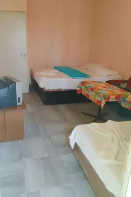 a room with two beds and a tv in it at Бунгала Дъбрава in Shkorpilovtsi