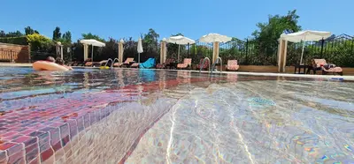 a large swimming pool with chairs and umbrellas at Dimi's River Park in Sunny Beach