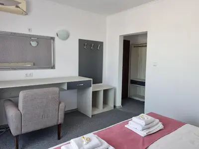 a bedroom with a bed and a desk and a chair at Dani beach Sozopol in Sozopol