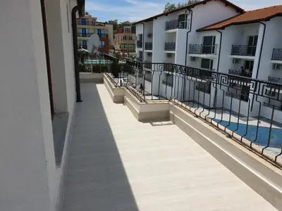 a balcony of a building with a pool and buildings at Dani beach Sozopol in Sozopol