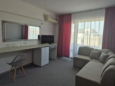 a living room with a couch and a desk with a television at Dani beach Sozopol in Sozopol