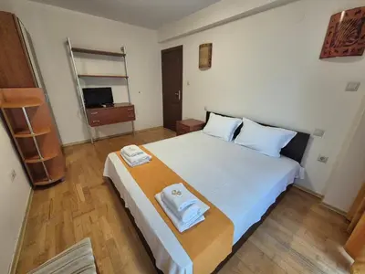 a bedroom with a large white bed with towels on it at Dani beach Sozopol in Sozopol
