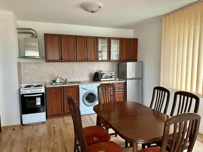 a kitchen with a wooden table and a table and chairs at Sozopol Dreams - Apartment №41 in Sozopol