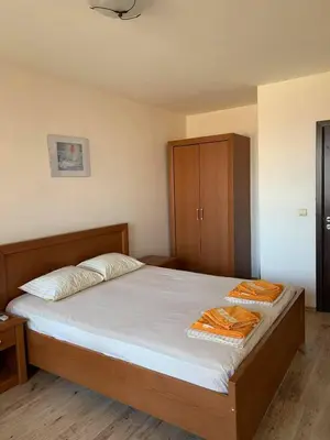 a bedroom with a bed and a wooden cabinet at Sozopol Dreams - Apartment №41 in Sozopol