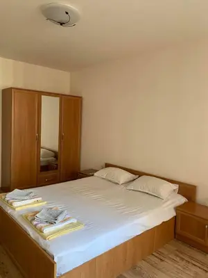 a bedroom with a large white bed with a cabinet at Sozopol Dreams - Apartment №41 in Sozopol