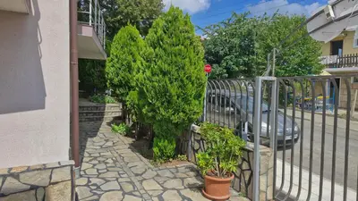 a fence with a tree next to a car at Family hotel Favourite in Obzor