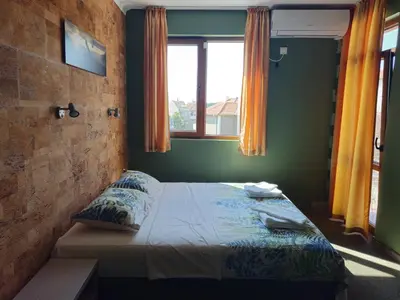 a bedroom with a bed in a room with a window at Family hotel Favourite in Obzor