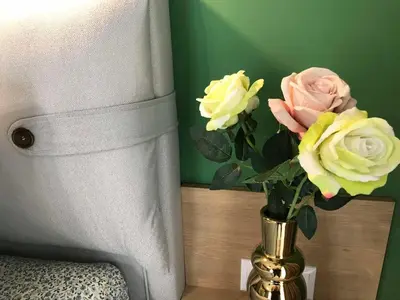 a vase with flowers in it next to a chair at Аpartment Bella Vista in Obzor