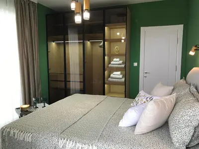 a bedroom with a large bed and green walls at Аpartment Bella Vista in Obzor