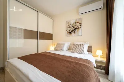 a bedroom with a large bed and a window at Summertime in Varna South Bay Beach Residence in Varna City