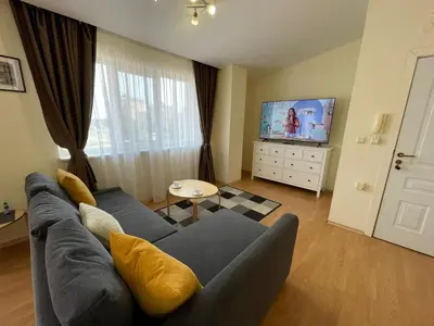 a living room with a blue couch and a tv at Green Fort - Prestige Sea Viev apartments in Sunny Beach