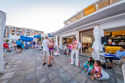 a group of people standing and sitting on a patio at Premier Fort Beach Luxury in Sveti Vlas