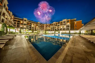 a resort with a pool and fireworks in the sky at Premier Fort Beach Luxury in Sveti Vlas