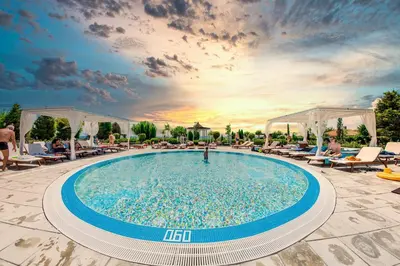 a pool at a resort with people sitting around it at Premier Fort Beach Luxury in Sveti Vlas